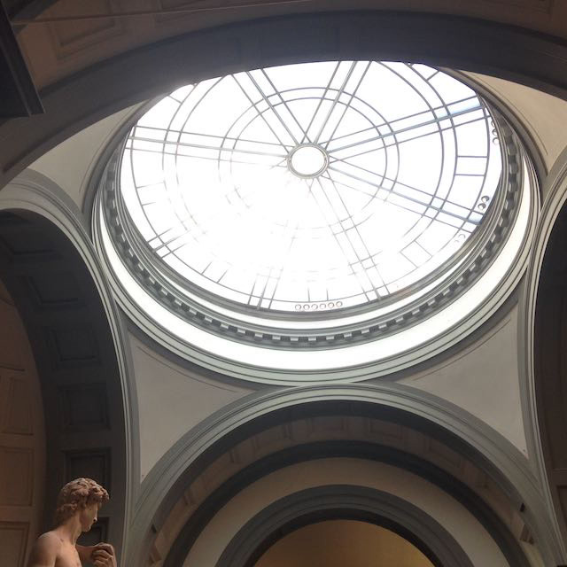 Interiør med glasskuppel og statue av David i hjørnet.