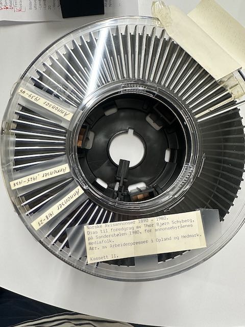 En lysbildekarusell for 35mm dias sett fra fugleperspektiv med påklistret etikett som sier Norske avisannonser 1890-1980. Dias til foredrag av Thor Bjørn Schyberg på Sandestølen 1980, for annonsebyråenes mediafolk.